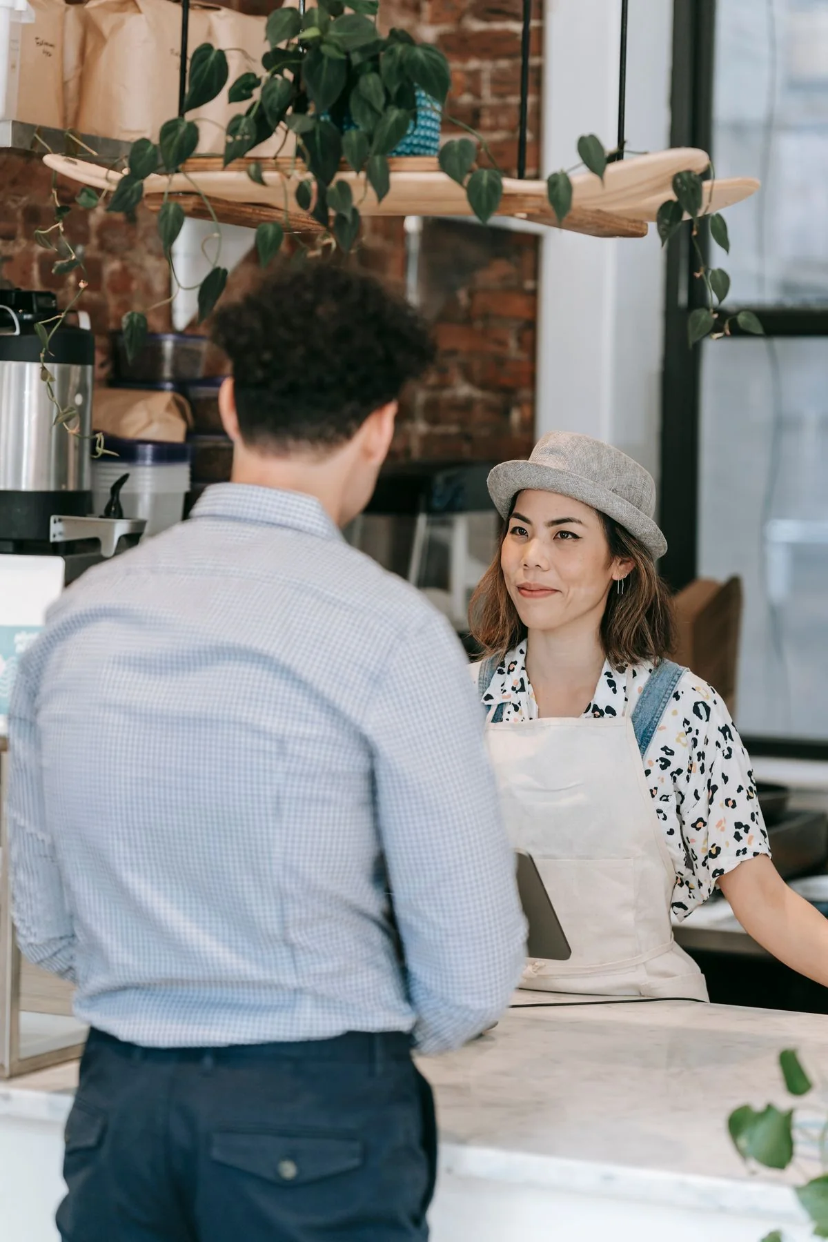 A barista listening to a customer at a café counter